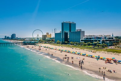 an aerial shot of hotels at myrtle beach south carolina oceanfront with buildings and ferris wheel in the background